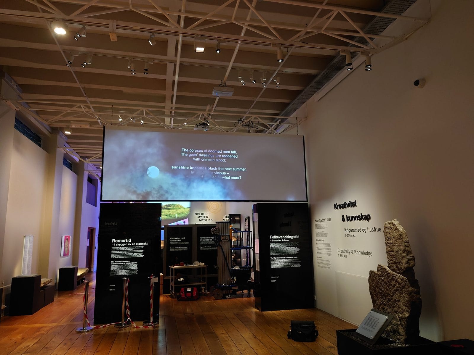 Utstillingssal på Arkeologisk museum med storskjerm og montre