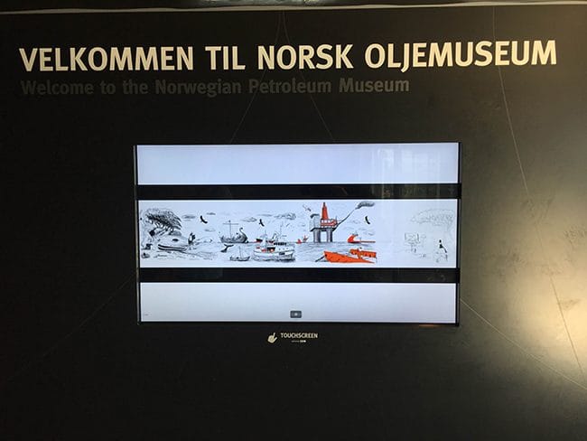 Infoskjerm under skiltet «Velkommen til Norsk Oljemuseum» i resepsjonen