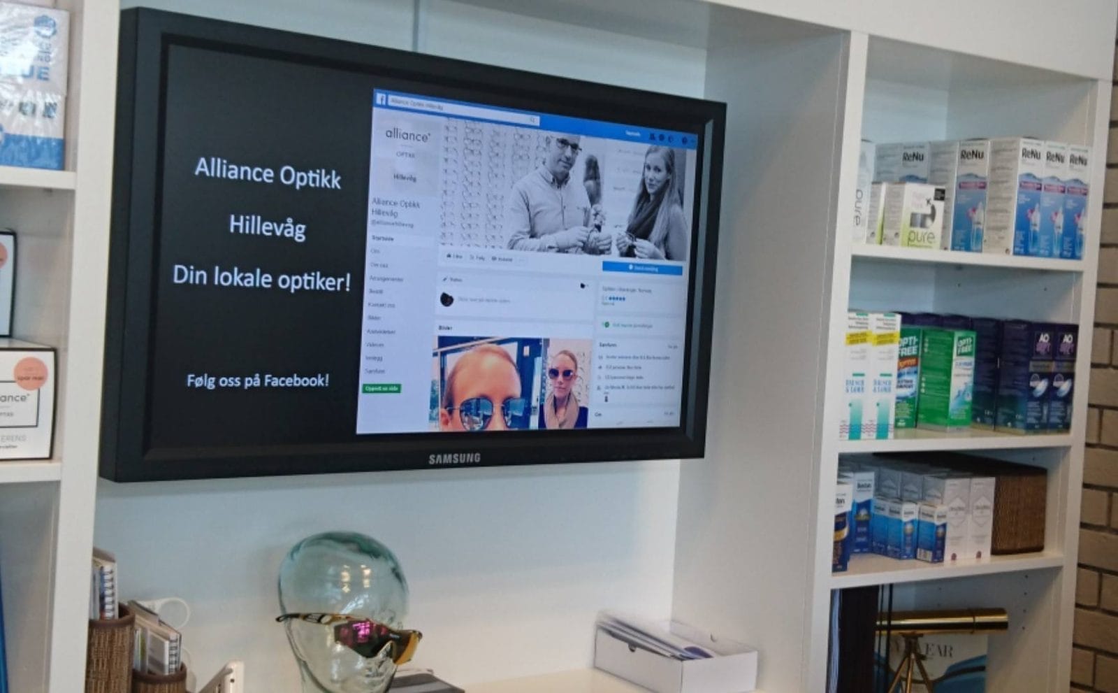 Infoskjerm i en optikerbutikk som viser butikkens Facebook-innlegg